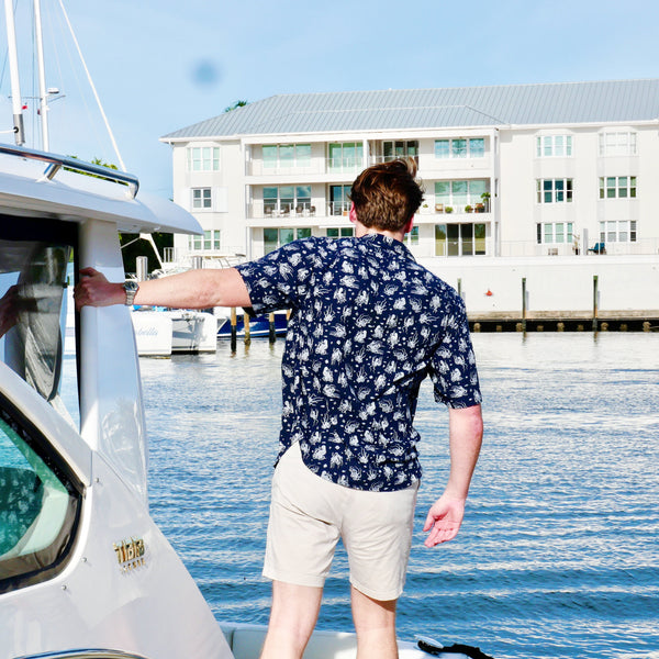 Man standing next to a boat on a dock with buildings in the background
